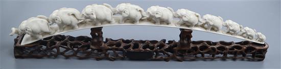 A Chinese carved ivory ten-elephant bridge on pierced carved hardwood stand, L 58cm